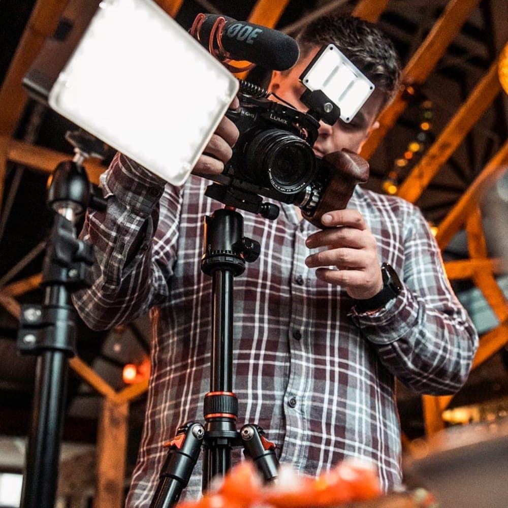 Louis filming with a camera, light and microphone on a tripod