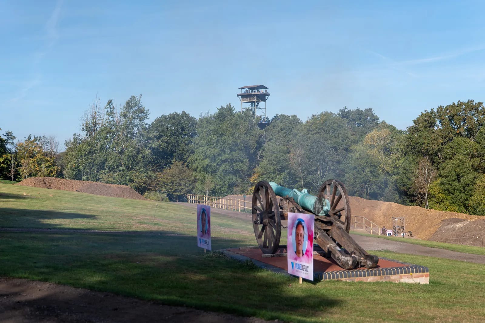A bronze cannon on the lawn at the Holland & Holland shooting ground, a lookout tower behind the trees