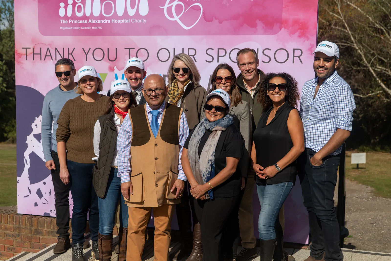 Guests in front of the sponsors' thank-you board