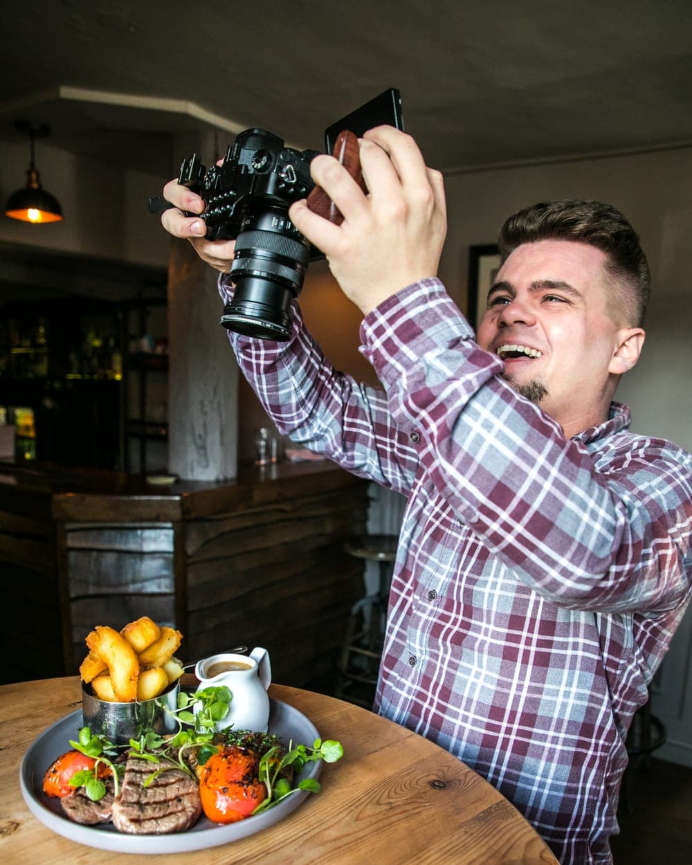 Louis Hopkins photographing a plated dish in a restaurant